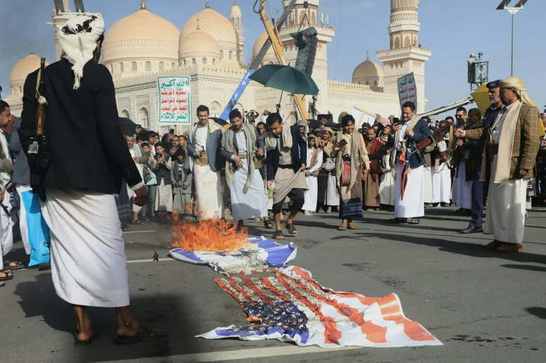 Protesters burn flags at a demonstration.