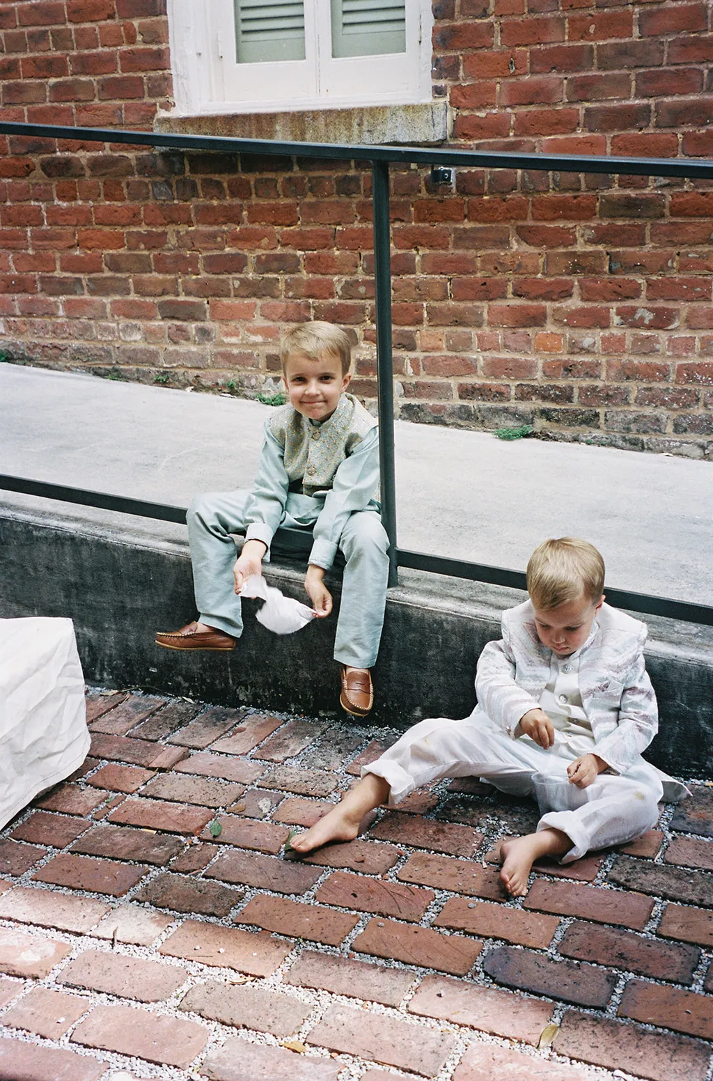 Image may contain Clothing Pants Person Sitting Jeans Child Brick City Footwear Shoe Face Head and Photography