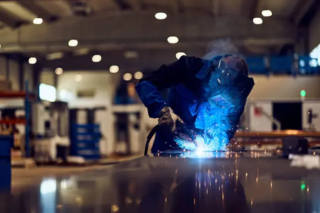 Industrial Worker Welding Metal in a Workshop with Bright Sparks