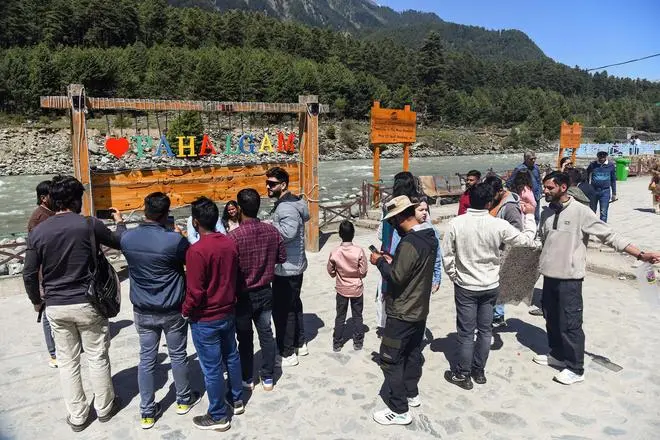 Tourists click photographs at Pahalgam town, on the first anniversary of Pahalgam terror attack Tourists click photographs at Pahalgam town, on the first anniversary of Pahalgam terror attack