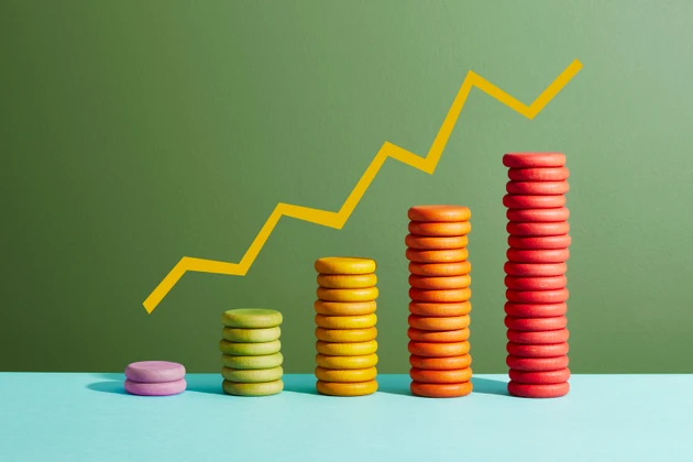 Five stacks of coloured coins with a graph line above