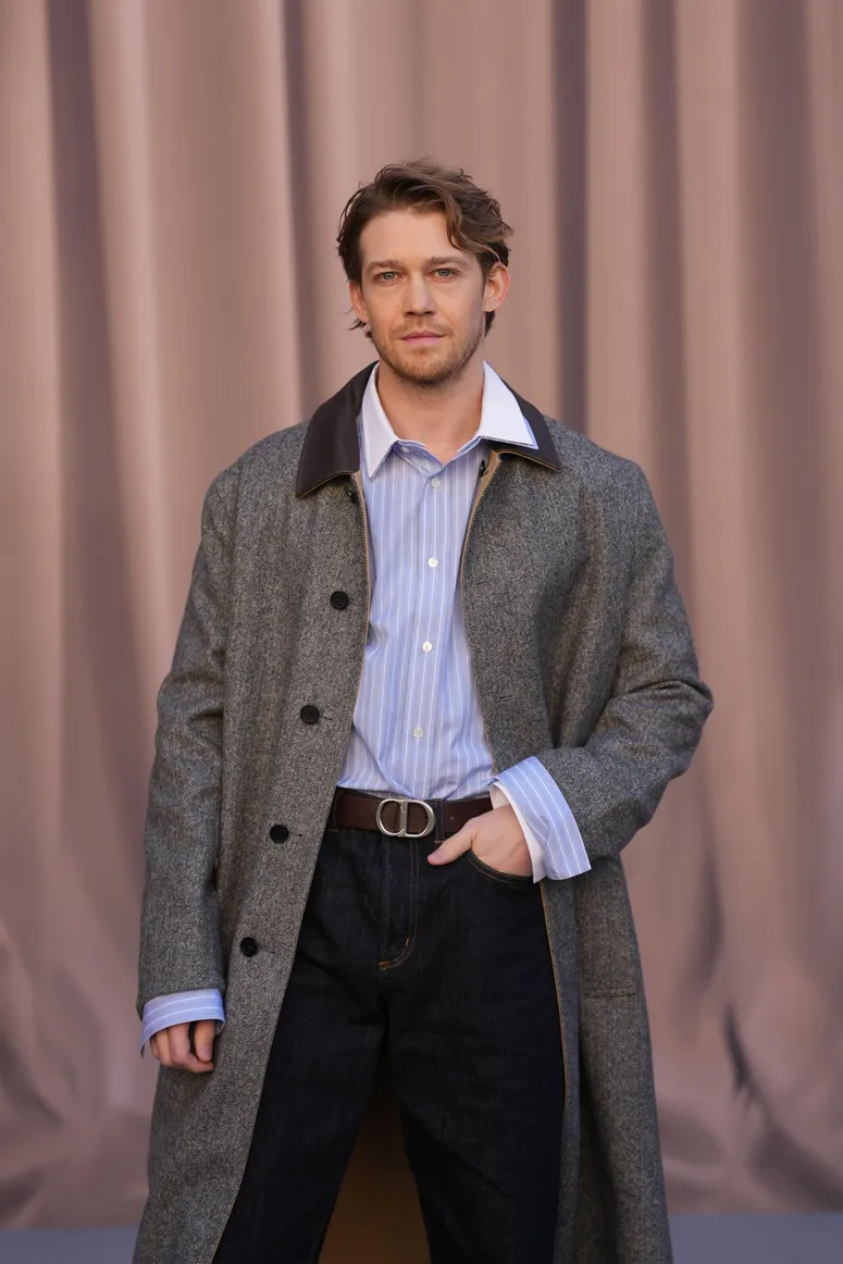 Image may contain: Joe Alwyn, Clothing, Coat, Blazer, Jacket, Adult, Person, Overcoat, Accessories, and Belt
