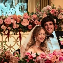 A couple smile at a lavish wedding surrounded by roses in a still from "Euphoria."