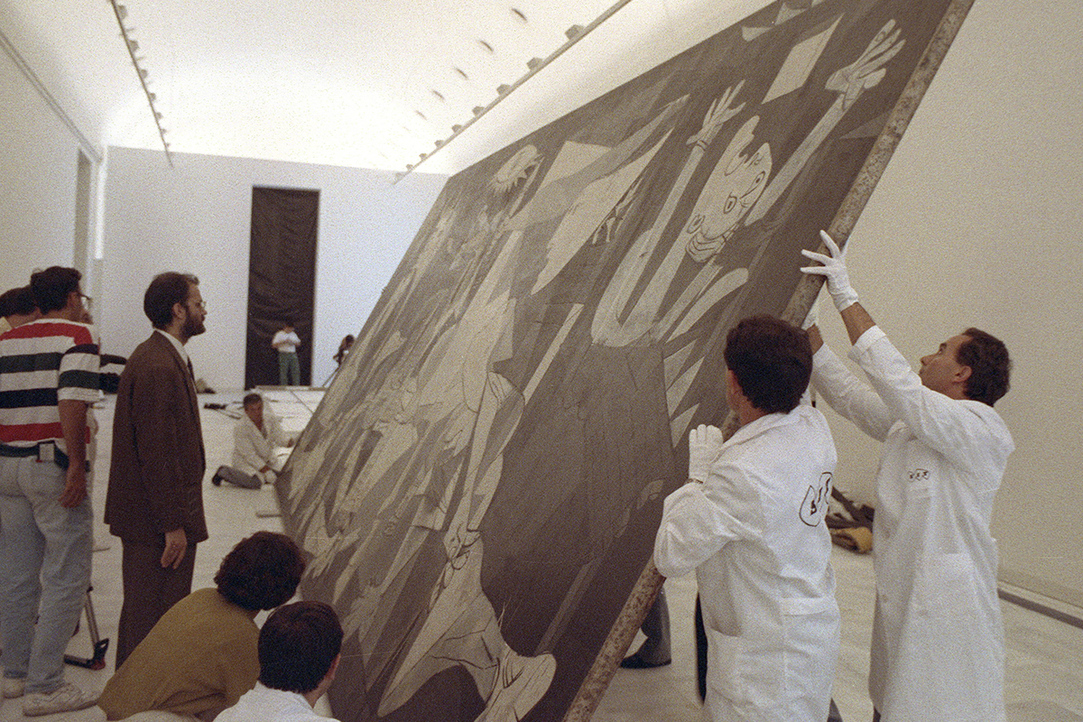 Los especialistas de la empresa SIT y del Museo Reina Sof�a en plena faena para colgar el mural de Picasso, de 350 kilos, en la sala de la segunda planta del edificio, donde descansa desde entonces.