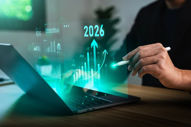 Businessman analyzing digital financial growth charts with upward trends and 2026 target, using laptop and stylus for strategic planning, investment forecasting, future business performance analysis