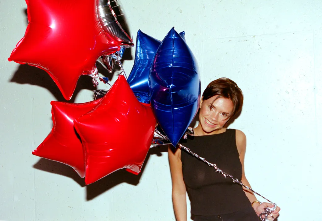 Image may contain Victoria Beckham Balloon Adult Person Face Head Photography Portrait Clothing Costume and People....