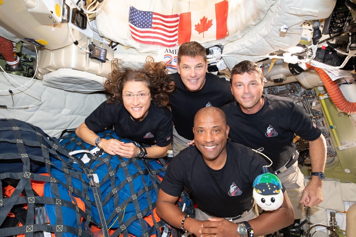 The Artemis II crew – clockwise from left: Christina Koch, Jeremy Hansen, Commander Reid Wiseman, and Victor Glover – pause for a group photo with their zero-gravity indicator Rise, inside the Orion spacecraft on their way home. Photo courtesy of NASA