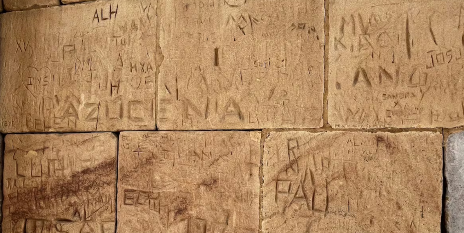 Pared del Templo de Debod marcada con varios nombres.