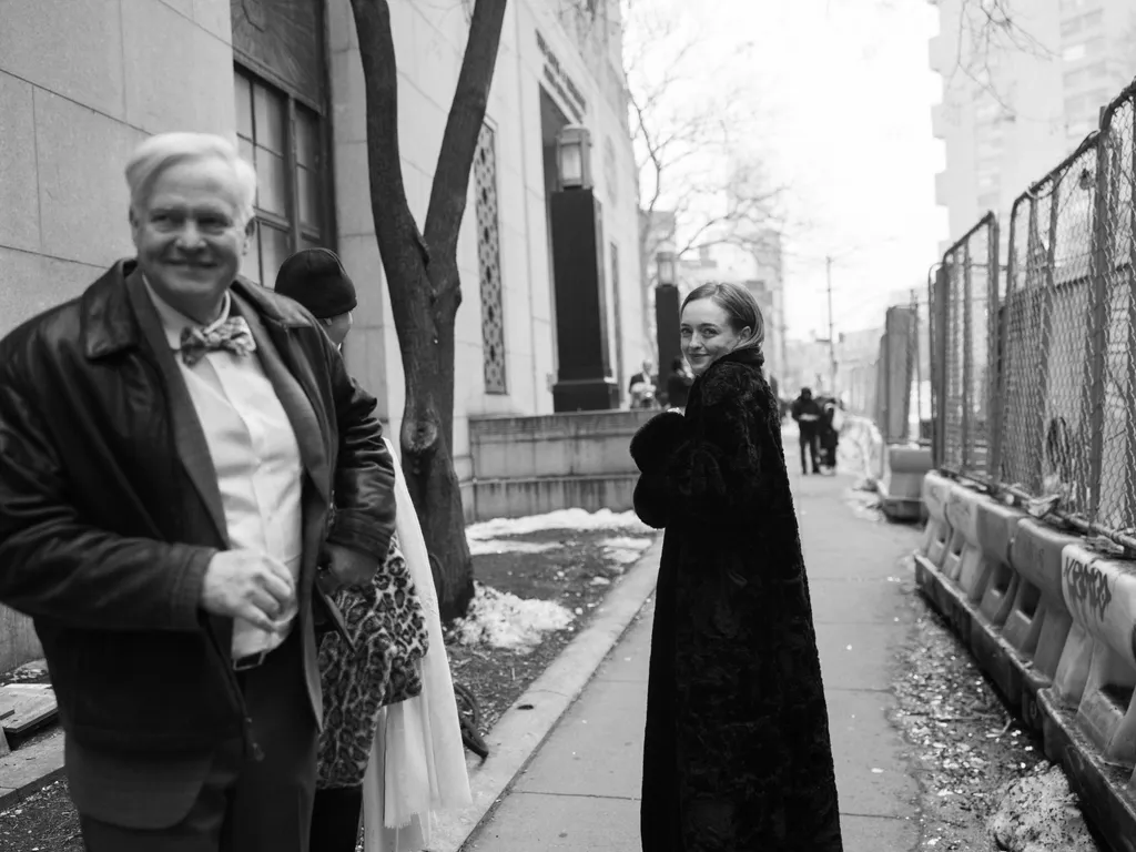 Image may contain Clothing Coat Path Sidewalk Dress Fashion City Road Street Urban Formal Wear Face and Head