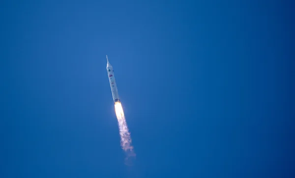 A Chinese Long March 10 rocket soars through a clear blue sky on a fiery exhaust plume