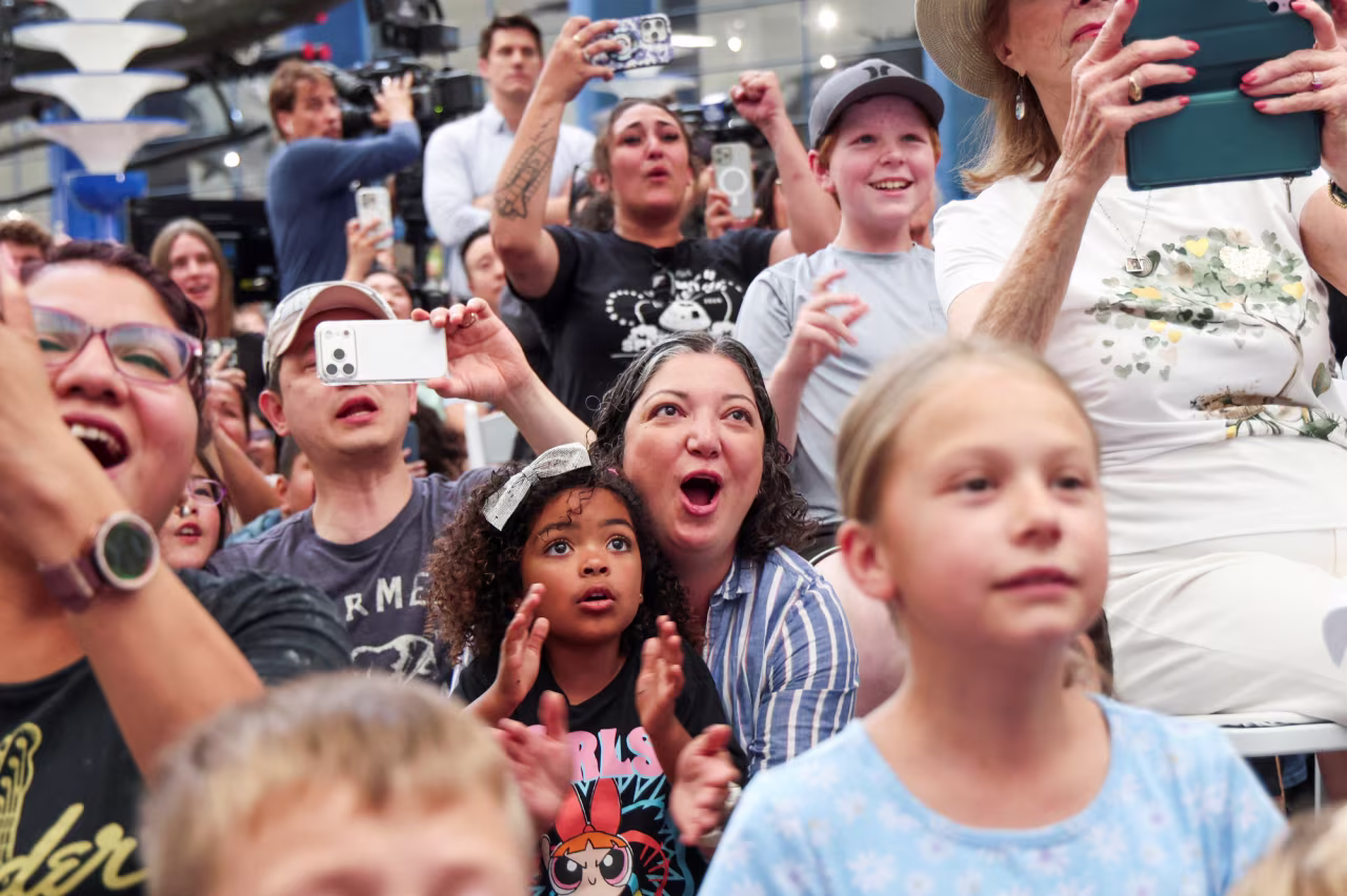 Crowds watch the Artemis II Orion capsule splash down off the coast of California at the San Diego Air and Space Museum on Friday.