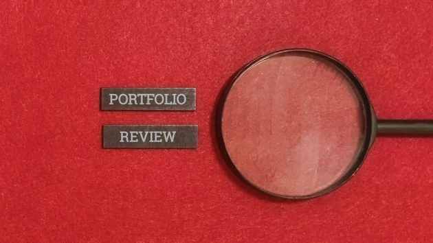 Magnifying glass on portfolio review with red background