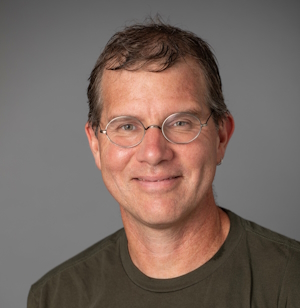 A man wearing glasses and smiling