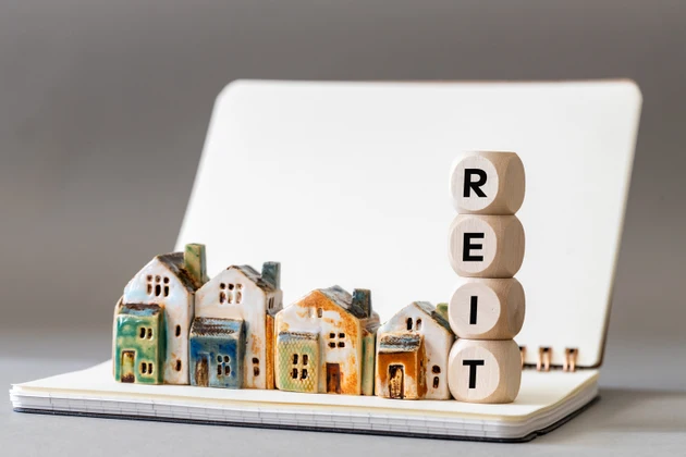 REIT symbol. Real Estate Investment Trust, Real Estate Investment Trusts with miniature houses Investment concept. copy space, business background