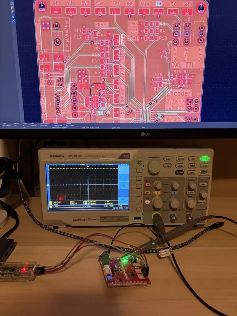 PCB layout open on screen, scope in the middle, dev board with the programmer below. Bench setup with the dev board, scope hooks on RX, and the PCB layout I kept re-checking