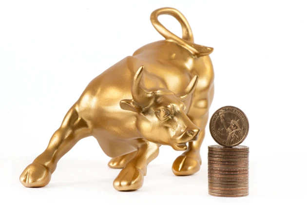 US $1 coin and a golden bull on a white background