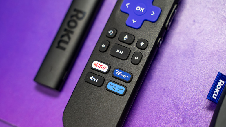 A Roku Streaming Stick next to its remote control.