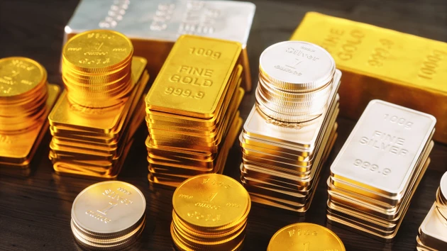 Shiny stack of gold and silver ingots and coins, close-up