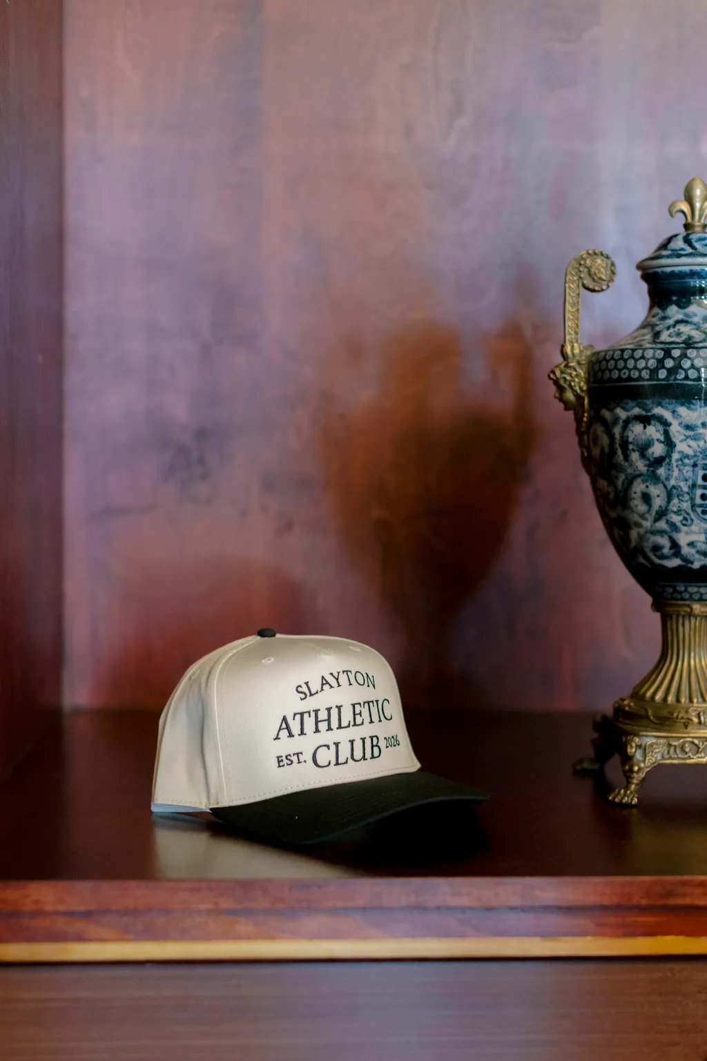 Image may contain Baseball Cap Cap Clothing Hat Pottery Jar and Wood