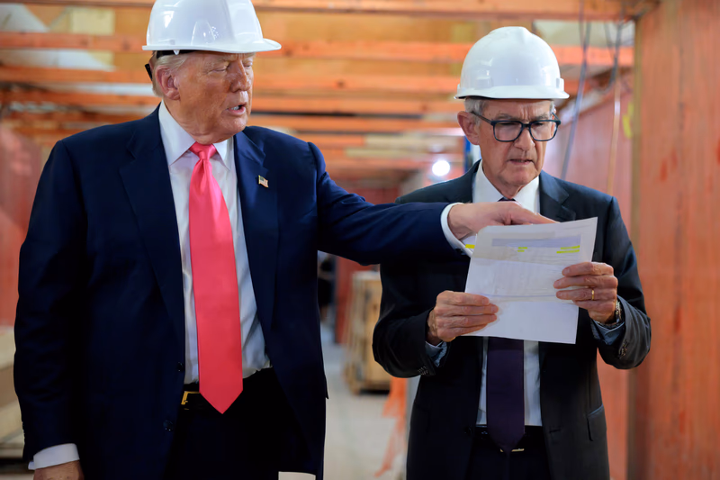 President Donald Trump standing next to Jerome Powell on a tour of the Fed's renovated office buildings, pointing to a sheet of paper in Powell's hands