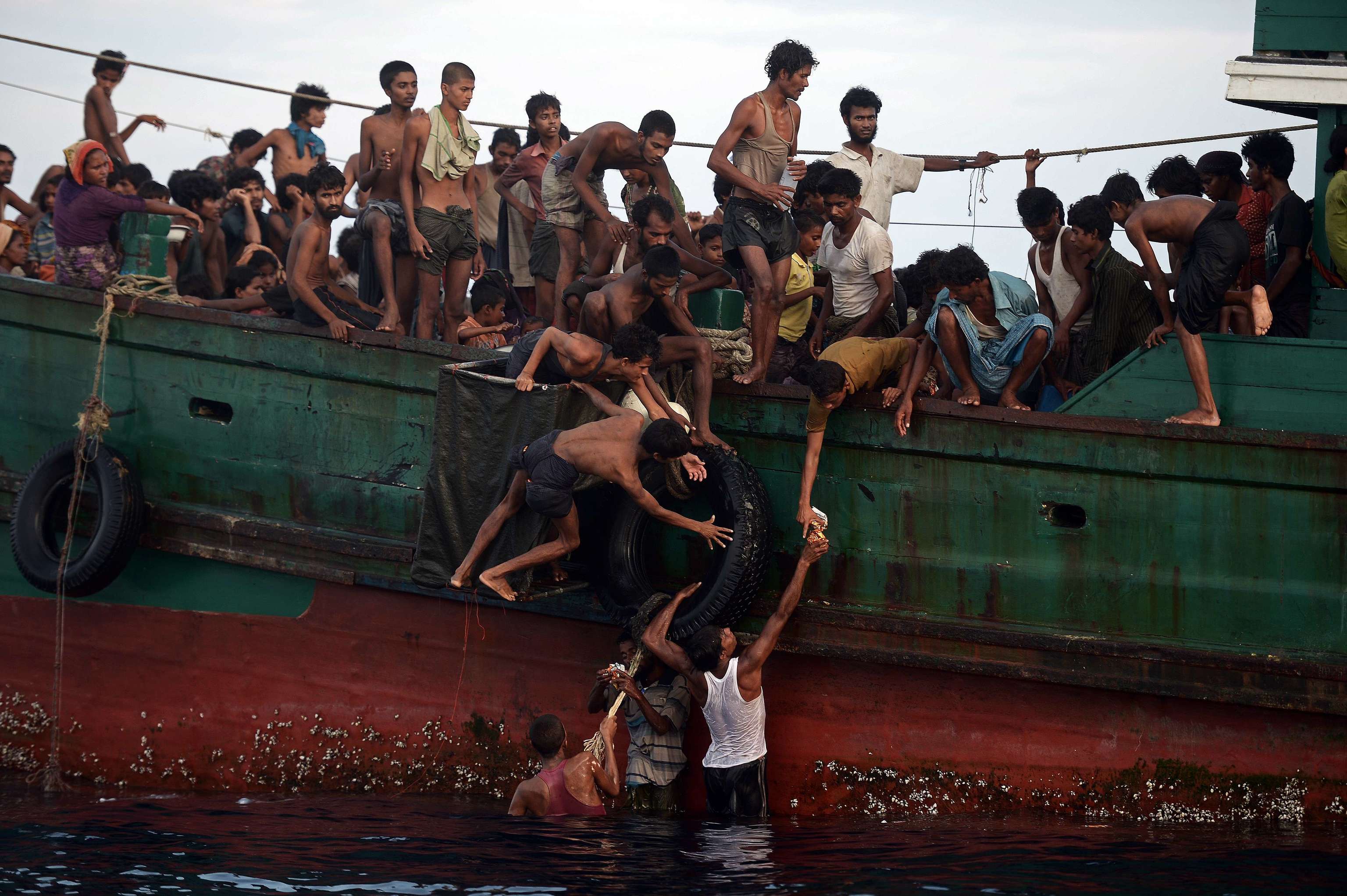 Varios rohiny�s entregan a otros integrantes de esa etnia comida para una traves�a en barco.