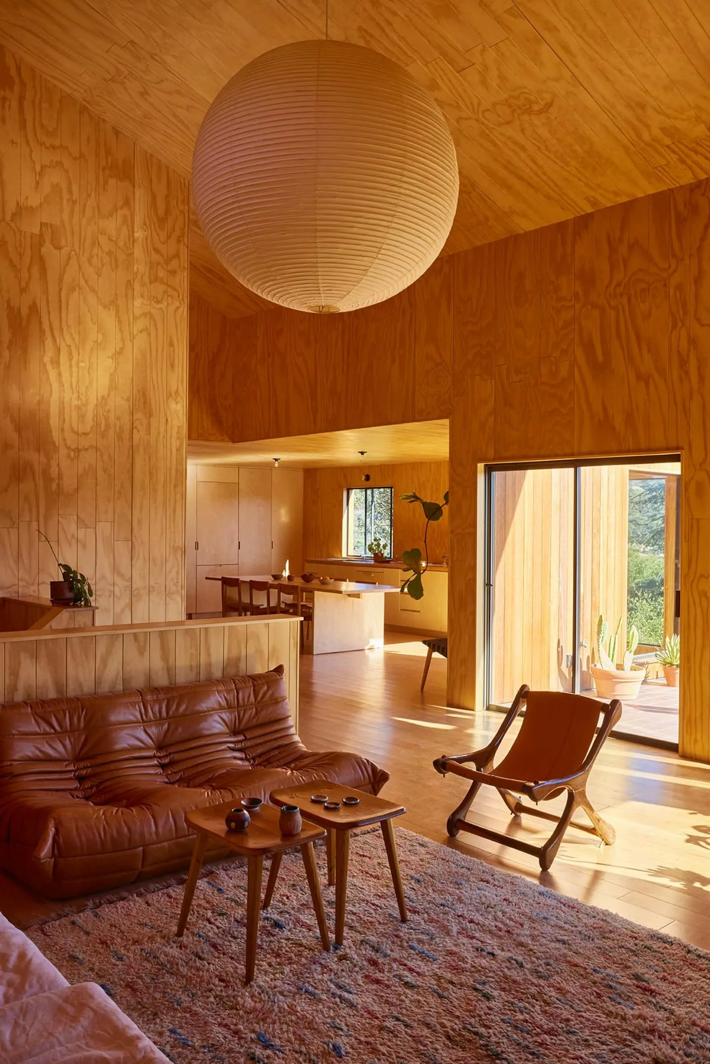 Image may contain Indoors Interior Design Wood Chair Furniture Home Decor Rug Plant Lamp Couch Floor and Hardwood