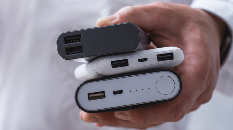 Someone holding a stack of portable power packs to charge mobile devices.