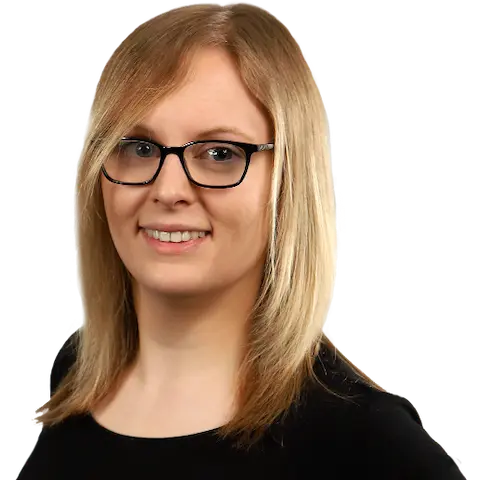 A smiling young woman wi…air wearing a dark top.