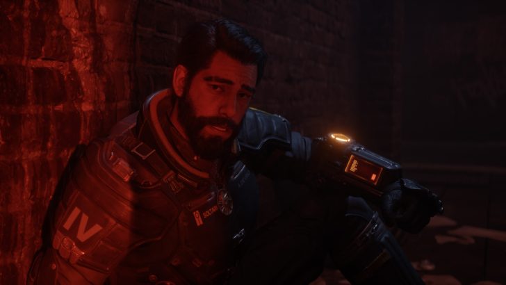 A character in 'Quantum Error' crouching against a brick wall, wearing a suit labeled 'IV' with an illuminated device on the arm.