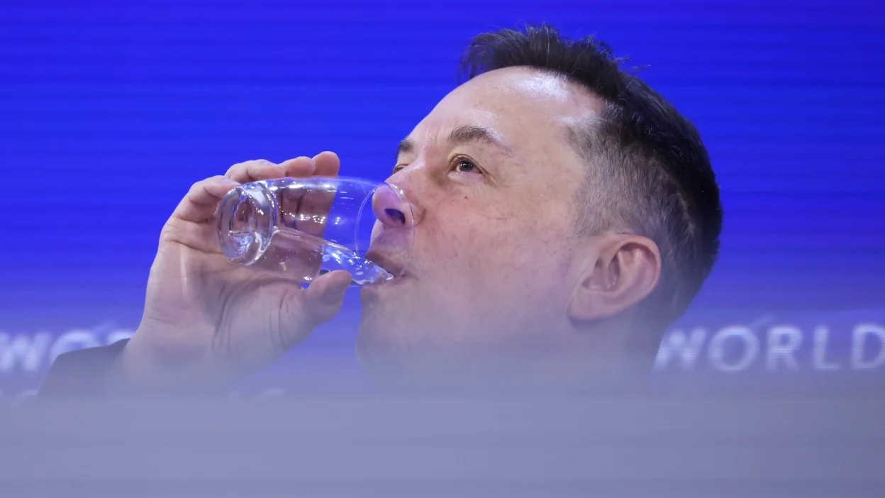 Elon Musk drinking a glass of water