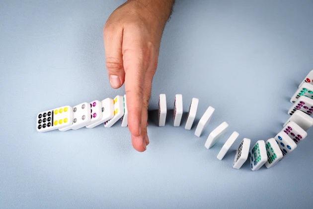 Stopping falling dominoes in a conceptual image of business crisis management