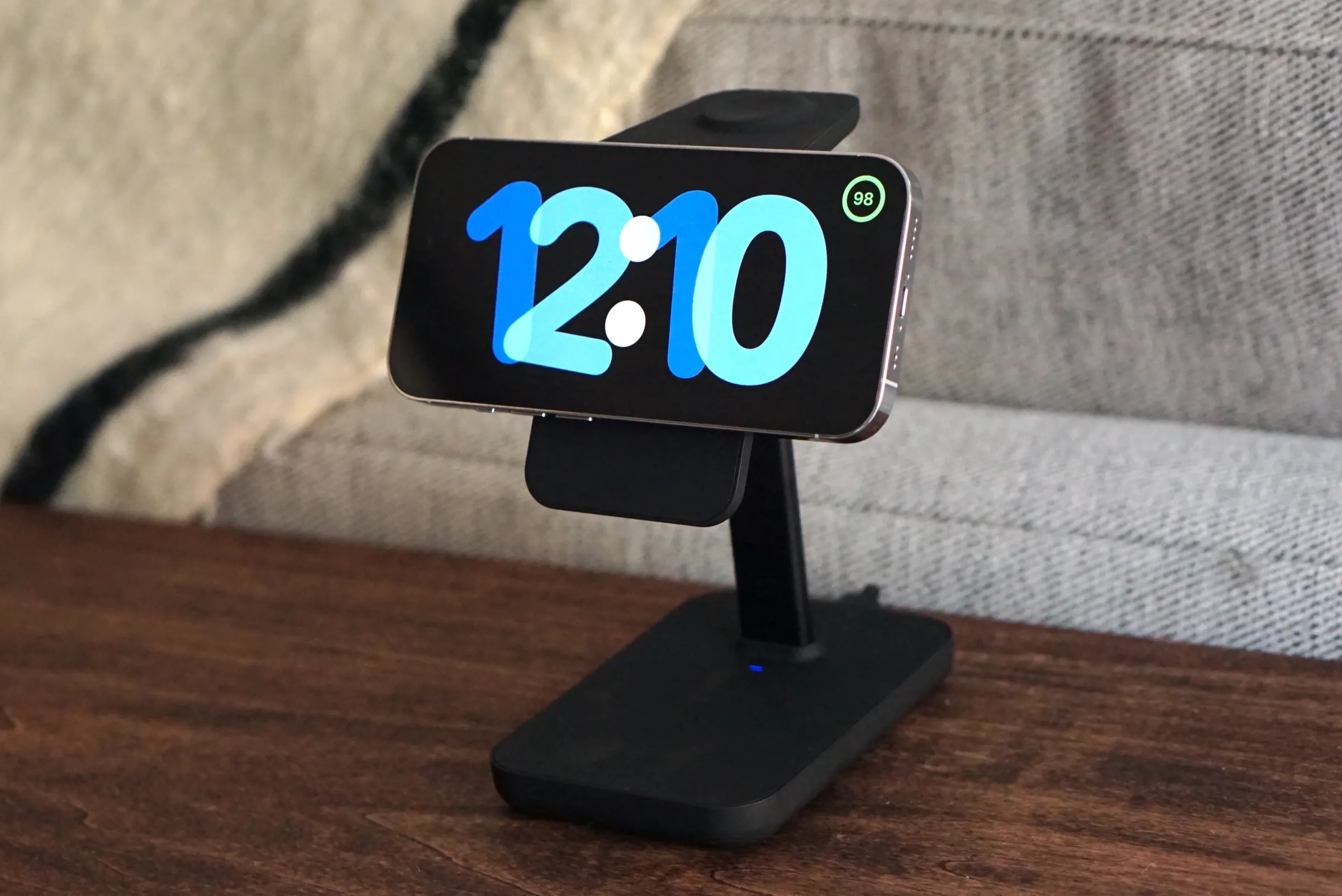 A photo of an iPhone in StandBy mode on a wood desk.