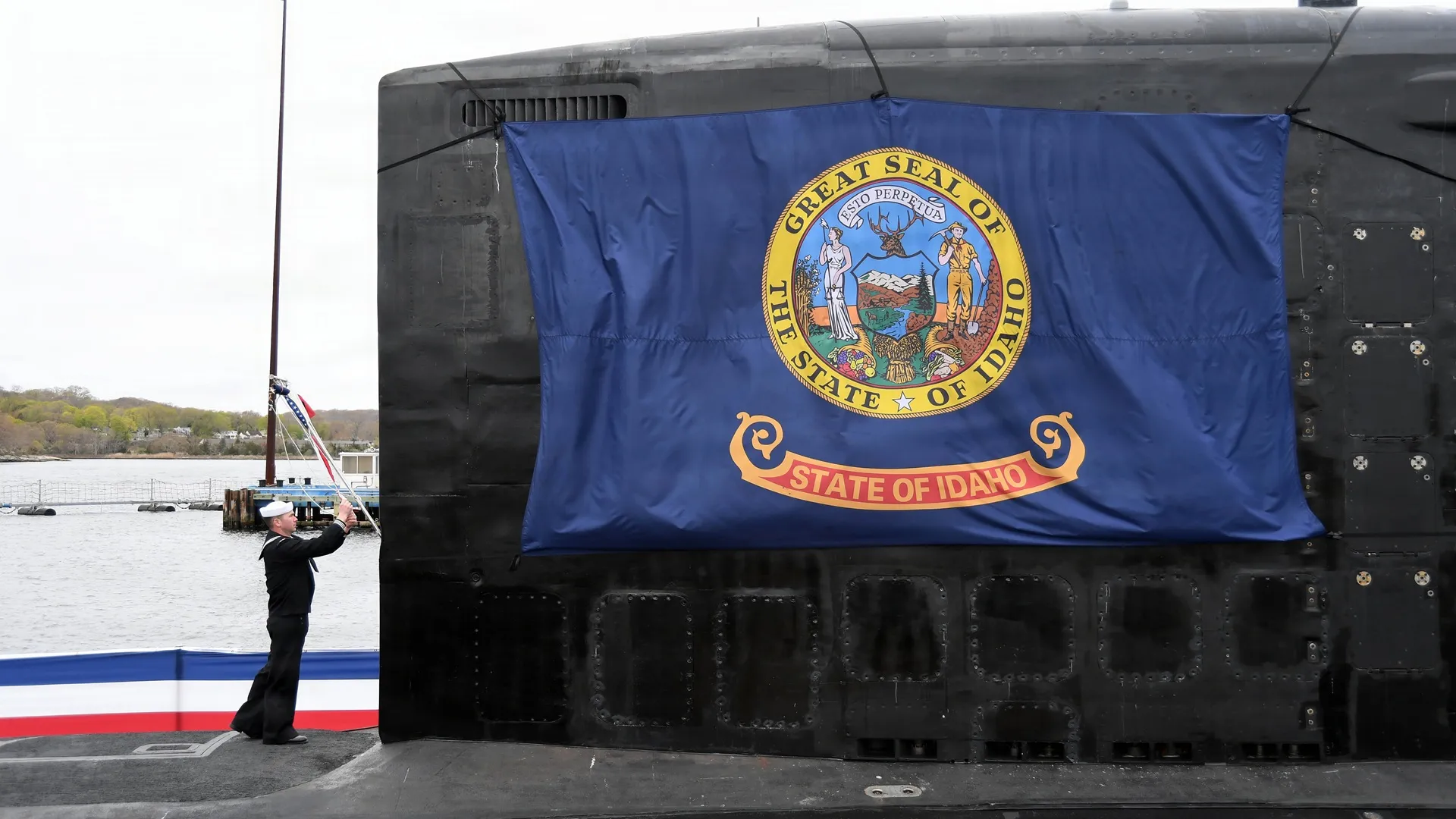 US Navy commissions giant 7,800-ton nuclear-powered attack submarine USS Idaho Electronics Technician 2nd Class Zachary M. Pion, raises the commissioning pennant during Idaho's commissioning ceremony.