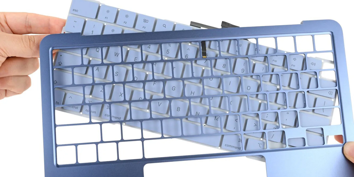 Apple gets bottom ranking for repairability of iPhones and MacBooks | Disassembled MacBok Neo keyboard shown