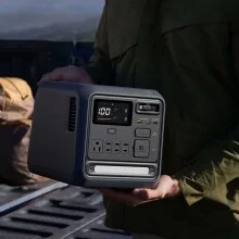 the DJI Power 1000 Mini being carried by a person who's standing near a truck outside