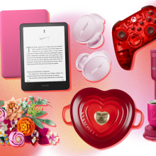 LEGO flower bouquet and box, burgundy Keurig, Kindle Paperwhite with pink case, red heart-shaped Le Creuset cast iron dish, pink Bose wireless earbuds, and red wireless Xbox controller arranged on pink, orange, yellow, and white backdrop