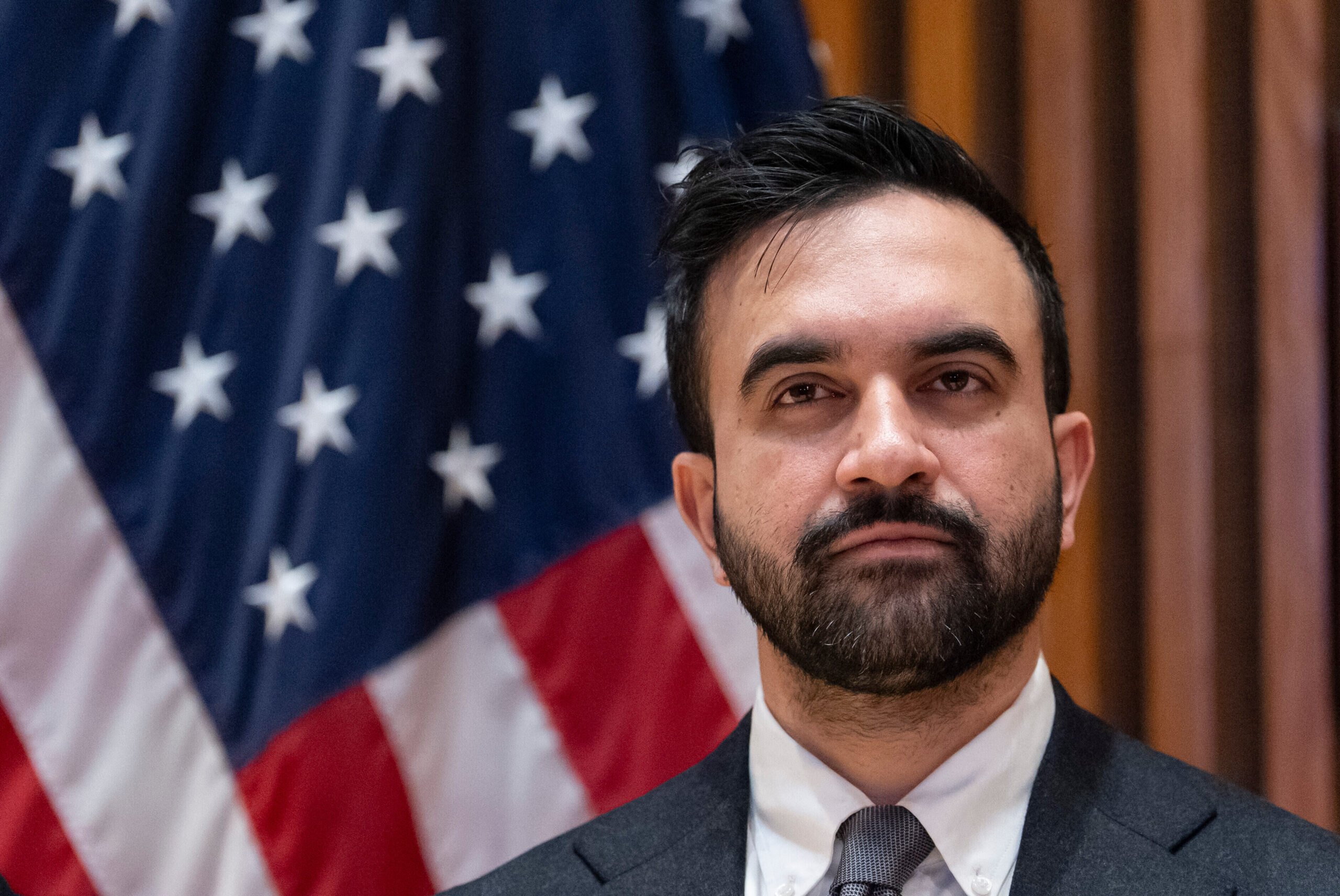 NYC Mayor Zohran Mamdani in front of an American flag