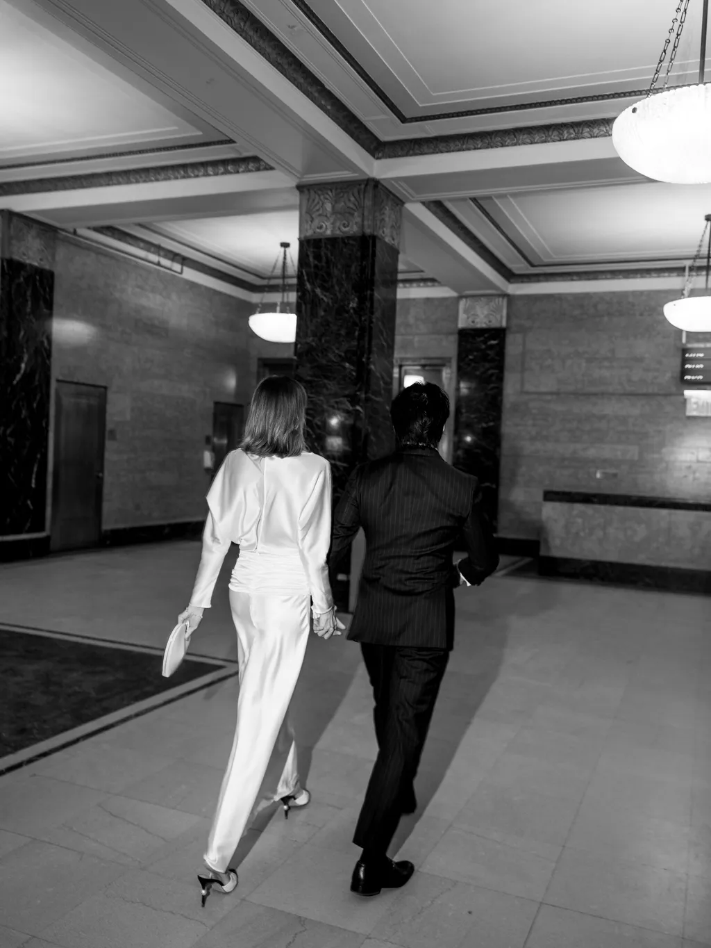 Image may contain Clothing Formal Wear Suit Floor Flooring Adult Person Long Sleeve Sleeve Dress and Lighting