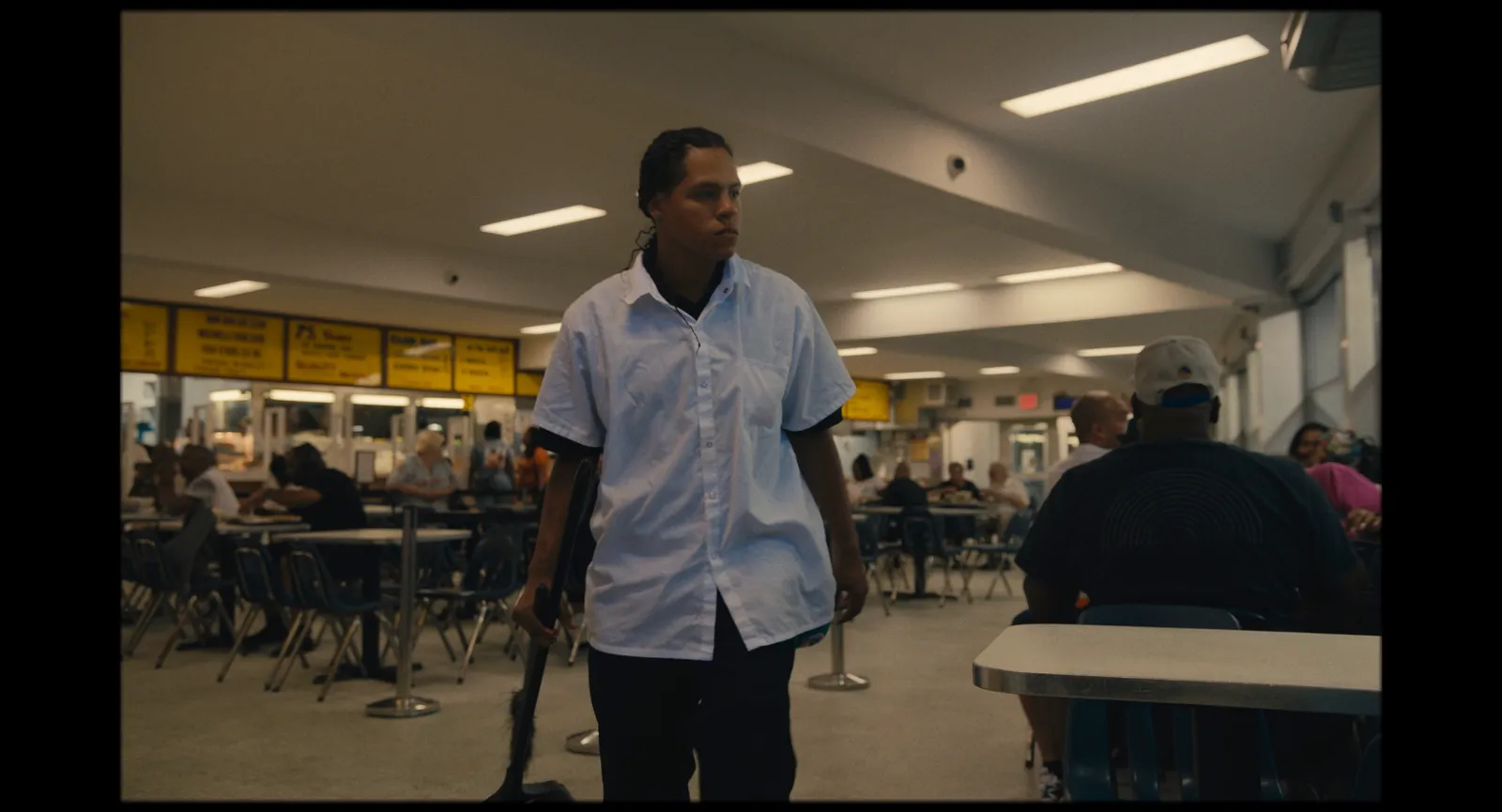 Image may contain Indoors Restaurant Adult Person Clothing Shirt Standing Cafeteria Accessories Bag and Handbag