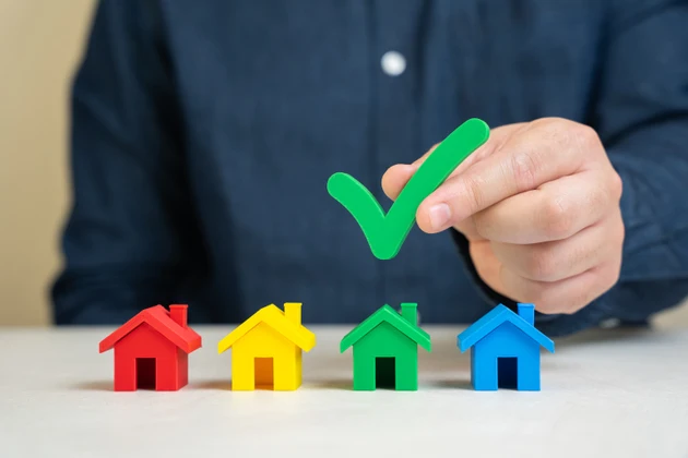 Man selects a house with a tick. The best choice of housing. Competition winner. Choosing a home to buy. real estate agent service. Check for legality and status of households. Affordable apartments choices
