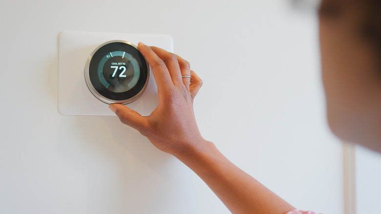 User adjusting smart thermostat