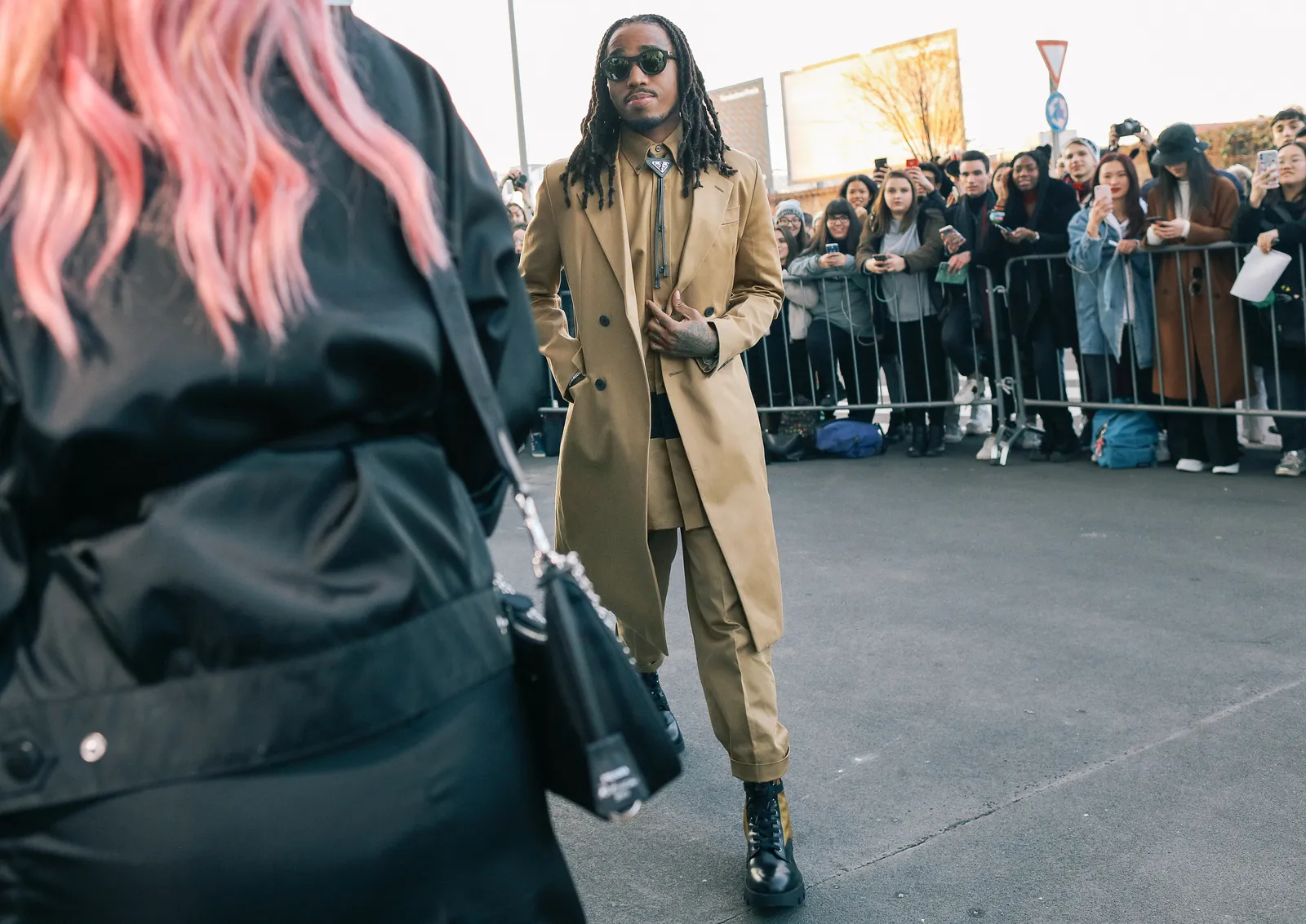 Image may contain Clothing Apparel Human Person Coat Overcoat Sunglasses Accessories Accessory Shoe and Footwear
