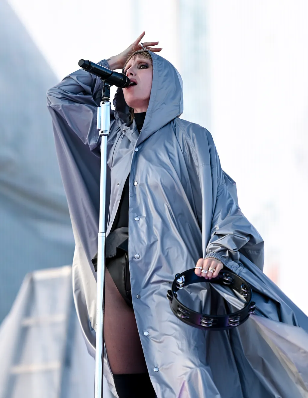 Image may contain Clothing Coat Performer Person Solo Performance Adult Electrical Device and Microphone
