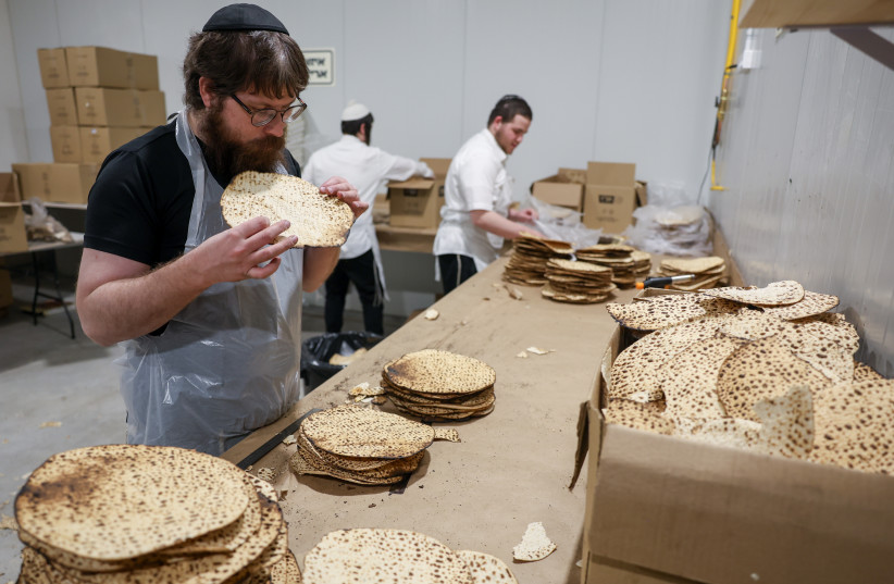Ultra Orthodox Jewish men prepare matzos, traditional unleavened bread eaten during the 8-day Jewish holiday of Passover, at the CHabad bakery on March 11, 2026.