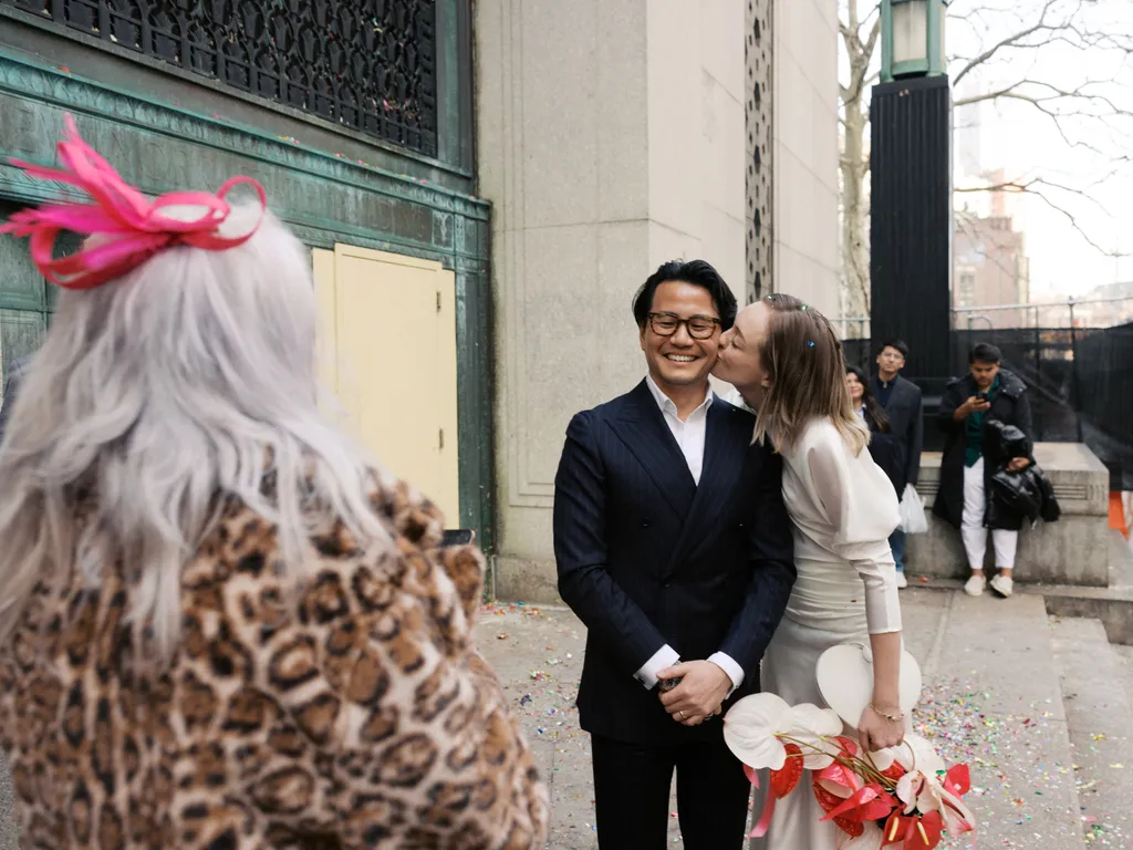 Image may contain Blazer Clothing Coat Jacket Formal Wear Suit Adult Person Wedding Flower and Flower Arrangement