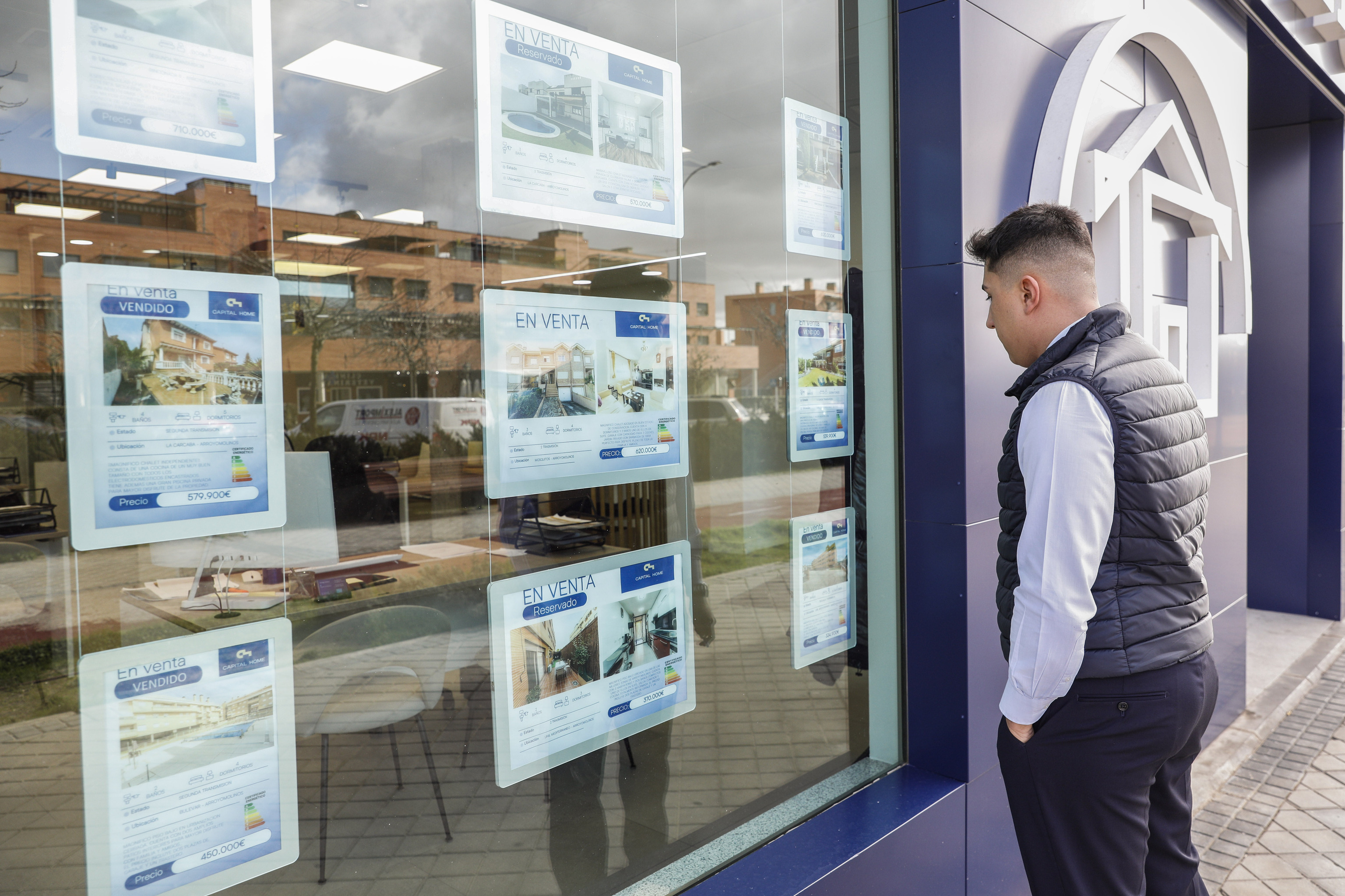 Una persona ve anuncios de viviendas en una inmobiliaria.