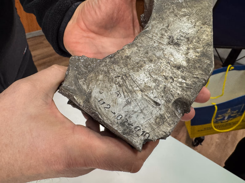Head of the Kharkiv Regional Prosecutor's Office Oleksandr Filchakov holds wreckage of a North Korean missile.