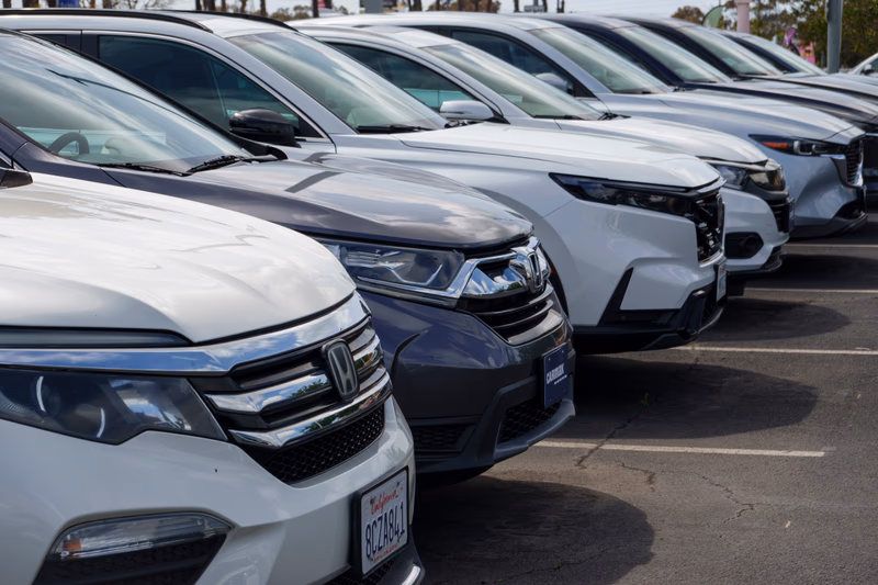 A lineup of cars in a parking lot.