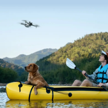 man and dog in kayak with DJI Mini 3 drone hovering overhead
