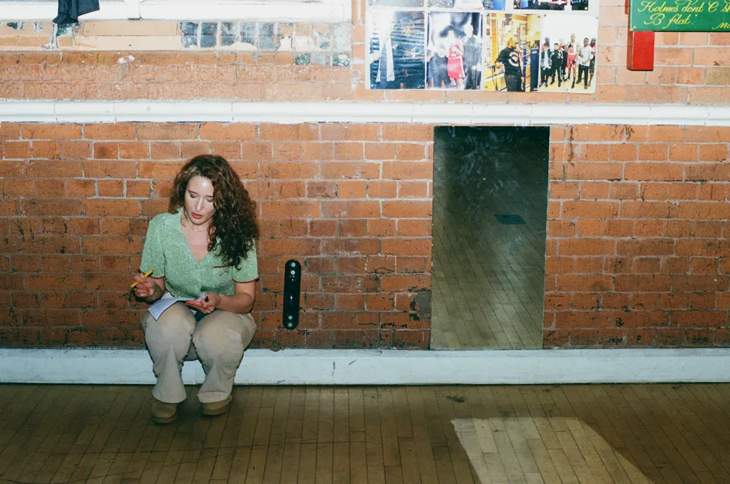Image may contain Adult Person Brick Curly Hair Hair Clothing Footwear Shoe Face Head Photography and Portrait